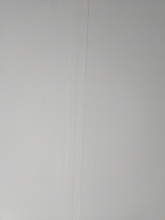 Spricka mellan gipsskivor på vägg som ska förberedas för tapetsering.