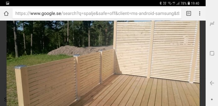 Träspaljé på altan med enhetlig design synlig från båda sidor, monterad i ett skogsnära område.