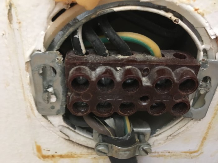 Eluttag med synliga ledningar och kopplingar i en vägg under installation eller reparation.