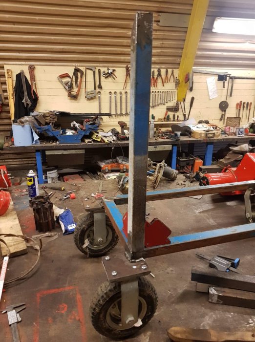 Nybyggd vagn med fyra hjul och stålram i verkstadsmiljö.