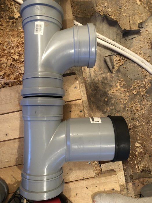 Avloppsrör med böj anslutna på trägolv, jämfört med en vanlig T-gren.