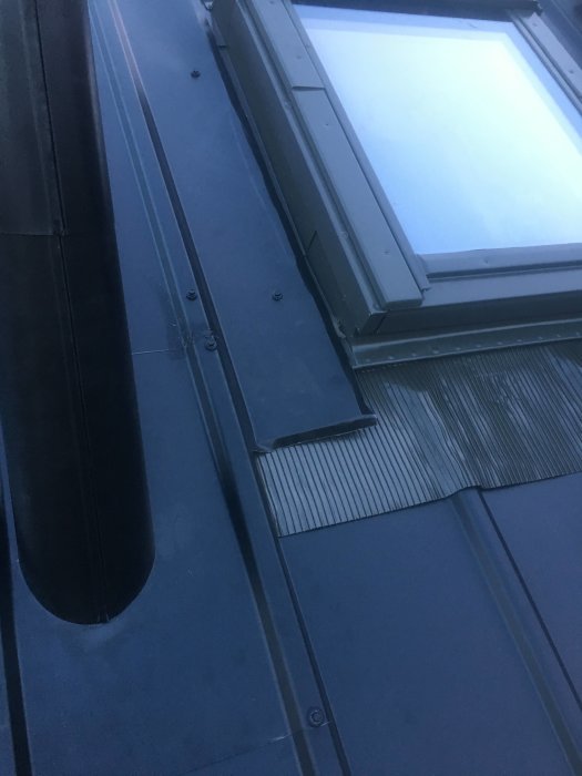 Nytt takfönster av märket Fakro på plåttak utan plåtavslutning, ersatt med korrugerad skiva.