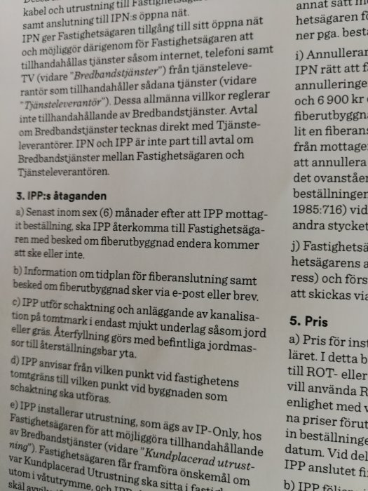 Närbild av ett dokument med text som beskriver avtalsvillkor för fiberoptisk anläggning och schaktningsarbeten.