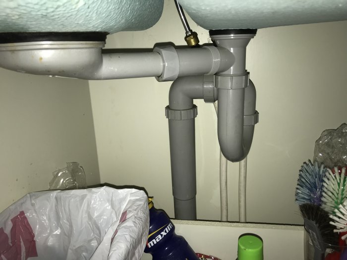 Avloppsrör och vattenlås under diskbänk utan anslutning för diskmaskin.