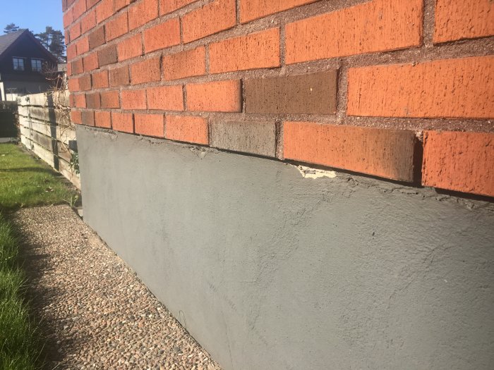 Vågrätt spricka i husgrund under tegelvägg, behov av tätning enligt besiktningsman.
