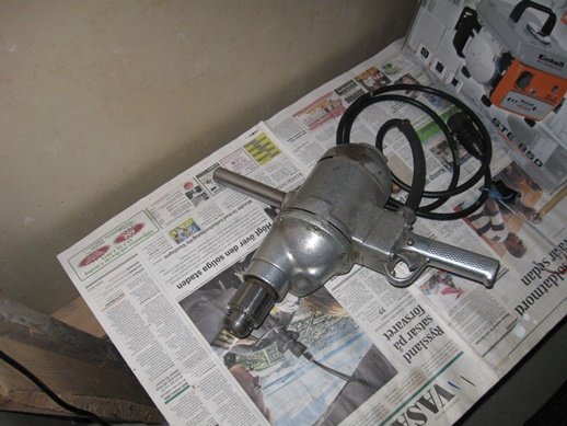 Äldre Naula tvåhandsmaskin liggande på tidningspapper, jämförd med nyare DeWalt och Makita-maskiner.