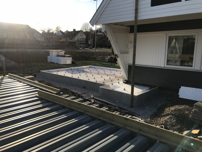 Hus under renovering med balkong och grundarbete, en del felaktigt förskjutet.