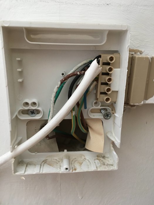Öppen eldosa med isolerade kablar och färgkodning, några kopplade och andra avslutade, vid en köksrenovering.