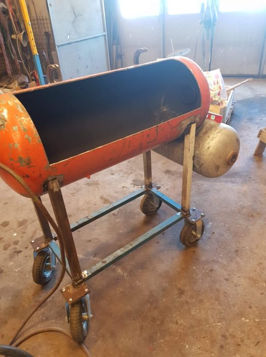 En improviserad röklåda och matkammare monterade på en hemmagjord vagn i en verkstad.