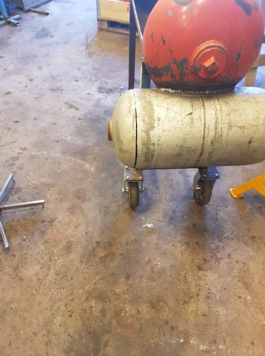 Rökugn under tillverkning med öppningsbar röklåda på hjul, samt gängstång och verktyg i en verkstad.