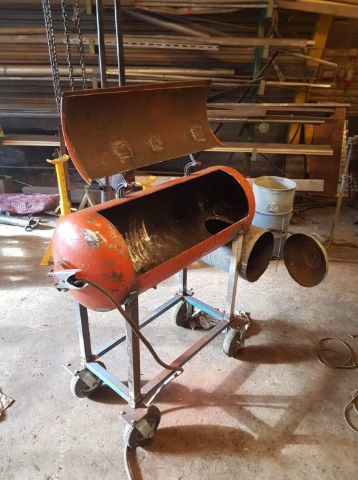En gammal sliten cementblandare på ett verkstadsgolv som en del av ett pågående renoveringsprojekt.