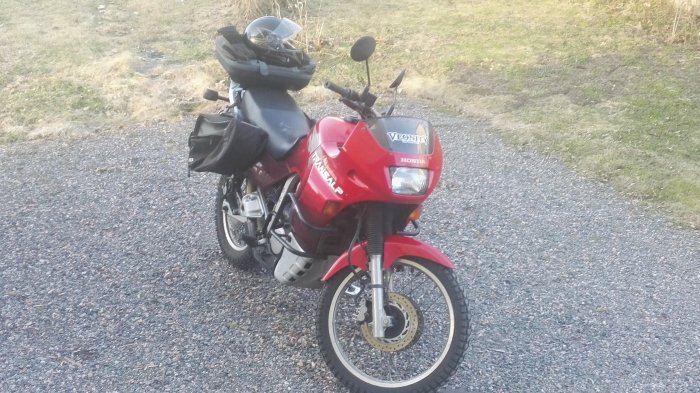 Röd Honda VFR motorcykel parkerad utomhus med nytt oljefilter, stift, och rengjord kedja.