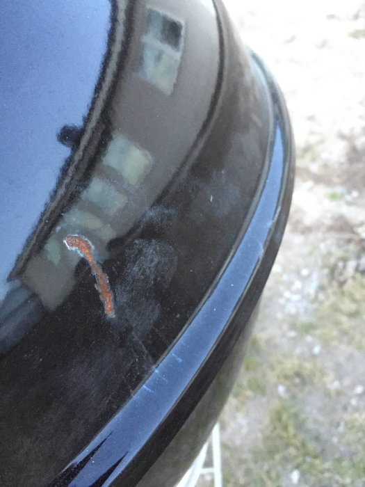 Närbild på grilllock med två bucklor och rostbildning.