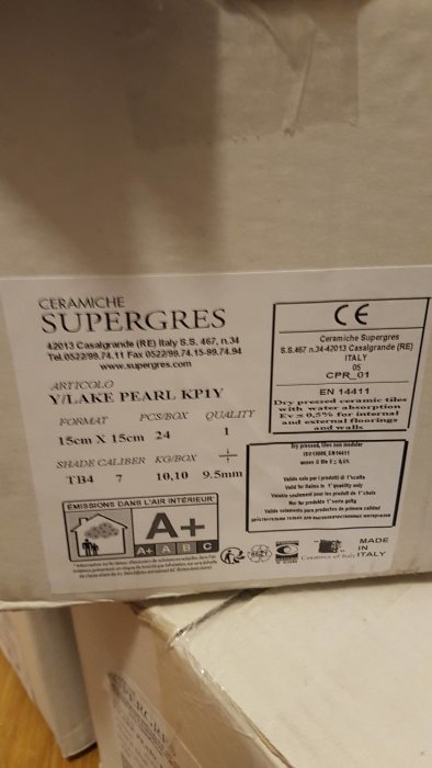 Kartong med information om klinker från Ceramiche Supergres, inkluderar storlek, kvalitet och miljöklassificering.