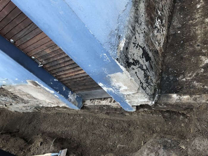 Uppgrävd grund vid hus med olika grunder från 30-talet och 70-talet under dräneringsarbete.