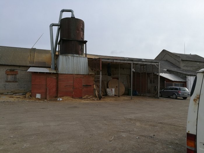 Industriområde med byggnader och material, tänkt att representera inköpsplats för kvistfri ek i Litauen.