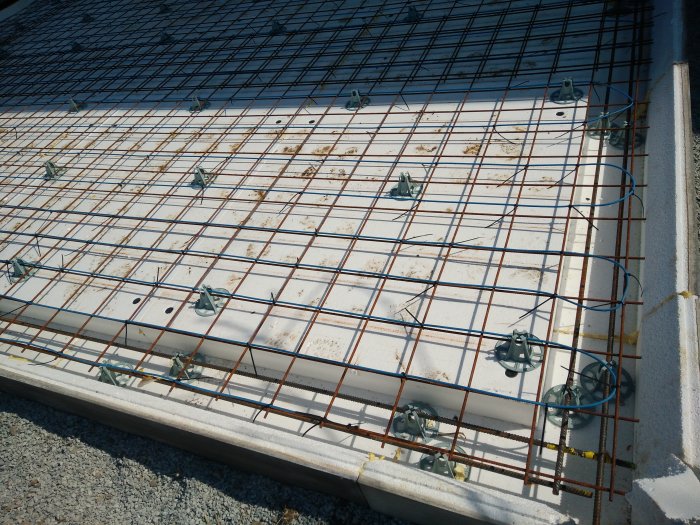 Armeringsnät fäst med buntband på isolermaterial vid byggprojekt.