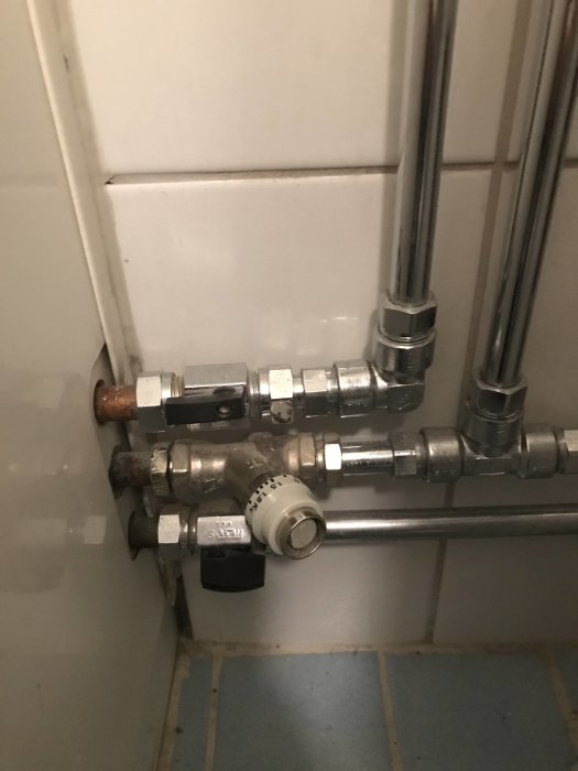 VVS-installation i badrum med ballofix, returventil och rör kopplat till en handdukstork.