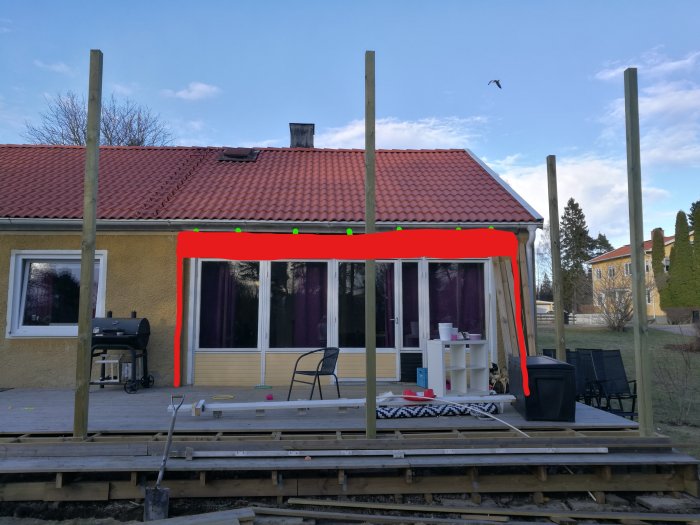 Altantak under renovering med markerade nya positioner för limträbalken och stolpar i rött på en husfasad med fönstervägg.