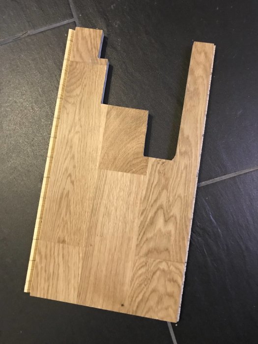 Golvplankor med specialkapning för att passa runt en trappkonstruktion.