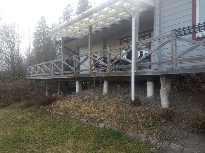 Altan under ombyggnation med tak och synliga plintar och reglar framför en byggnad.