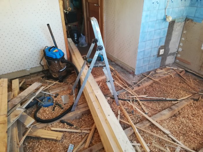 Renovering av golv med borttagna massiva träplankor, höjdutjämning med reglar och spill på golv.