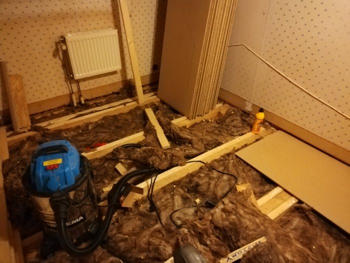 Renoveringsprojekt med golvvärme, visar höjdutjämning med reglar och mineralullsisolering på golv.