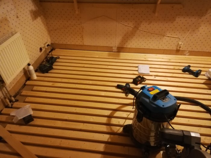 28mm glespanel förberedd för golvvärmeslingor med verktyg och en radiator i ett renoveringsprojekt.