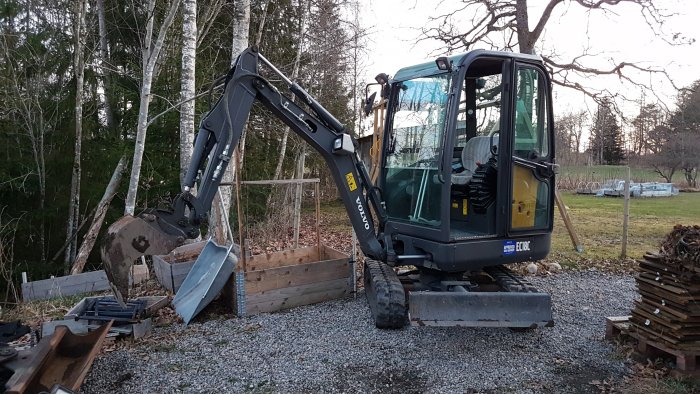 Grävmaskin på byggplats med markerade områden för plintar, redo för nästa dags arbete.