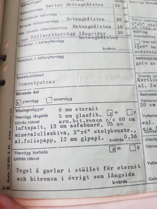 Närbild av ett gammalt byggnadsdokument som visar specifikationer för väggkonstruktioner i ett hus från 1967.