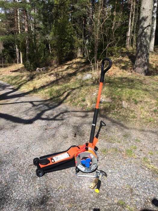 En Bahco BH13000 domkraft och en kabelvinda på en grusväg med skog i bakgrunden.