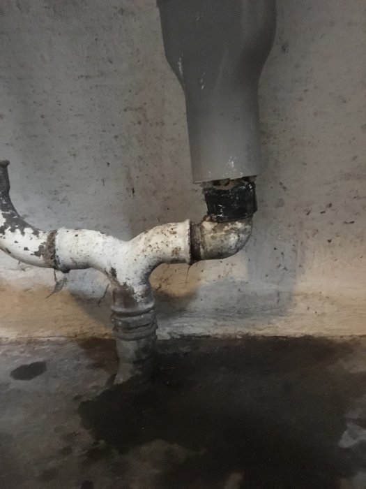Galvat 40mm avloppsrör kopplat till vattenlås med dålig övergång i tvättstuga.