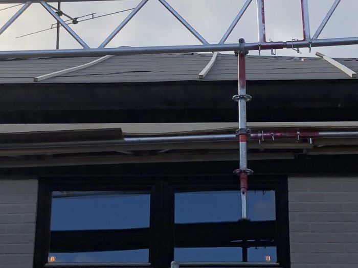 Tak under konstruktion med icopal yep2500 takpapp som inte ligger helt jämnt på råspont, visad med byggställning i förgrunden.