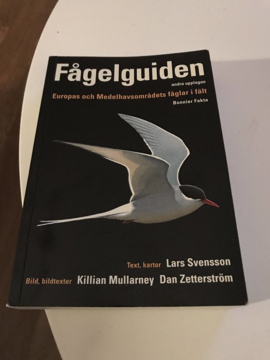 Boken "Fågelguiden" med bild på en flygande fågel samt författarnamnen på framsidan.