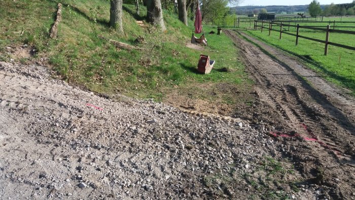 Uppgrävd väg med markerade linjer för fiberkabelinstallation i lantlig miljö.
