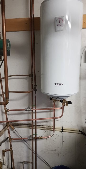 Nyinstallerad vit varmvattenberedare av märket TESY kopplad till kopparledningar utan synlig säkerhetsventil.