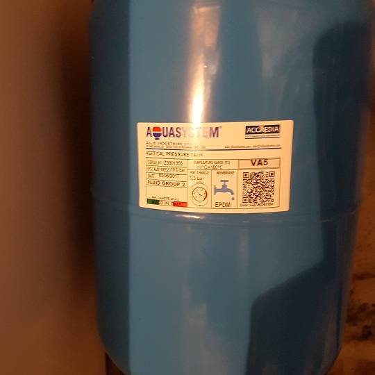 Blå trycktank för varmvattenberedare installerad i torpargrund.