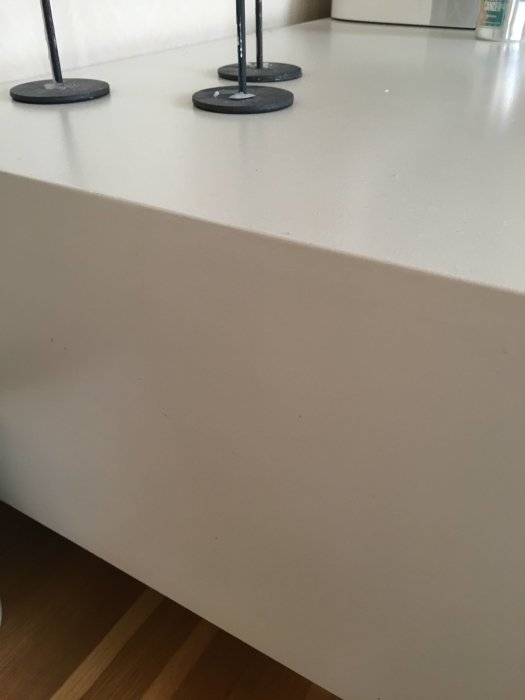 Oskadad vit köksbänkskant med förankringsdetaljer ovanpå, intakt efter 8 år.