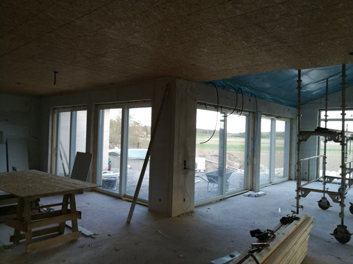 OSB-skivor installerade i ett oavslutat rumstak med synlig byggställning och material.