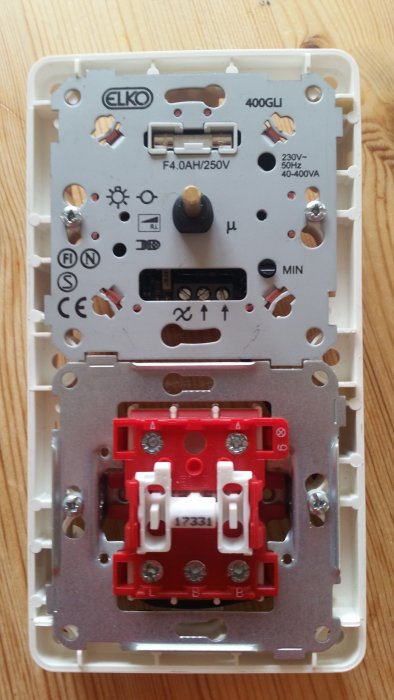 Baksidan av en ny strömbrytare med märkningen ELKO och olika anslutningsskruvar synliga.