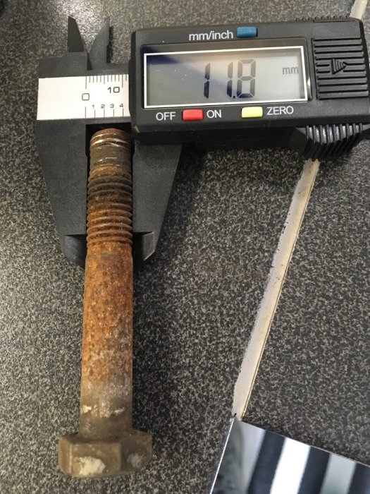 Digital skjutmått visar måttet 11.18 mm på en rostig sexkantskruv.
