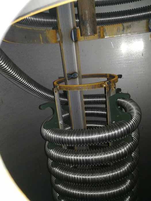 Interiör av en ny ackumulatortank med slingor och anslutningar, indikationer på vattenfyllning.