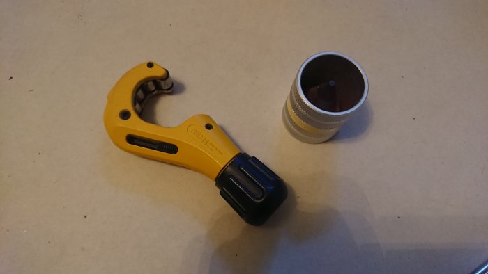 Rörkap och gradningsverktyg bredvid uppmätt kromat 15mm rör.