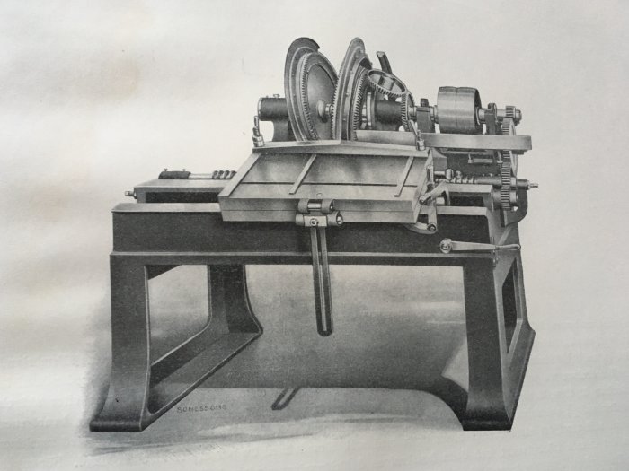 Svartvit bild av en klassisk sinkmaskin för gradsinkning och lådsinkning med robust konstruktion och stora kugghjul.