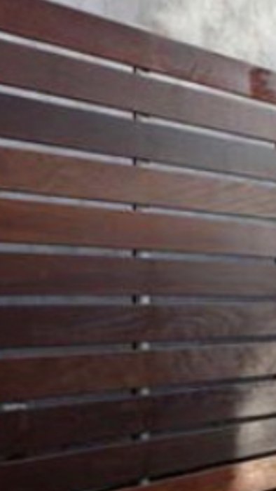 Horisontella mörkbruna träpaneler, möjlig teak, vanliga i maritima miljöer.