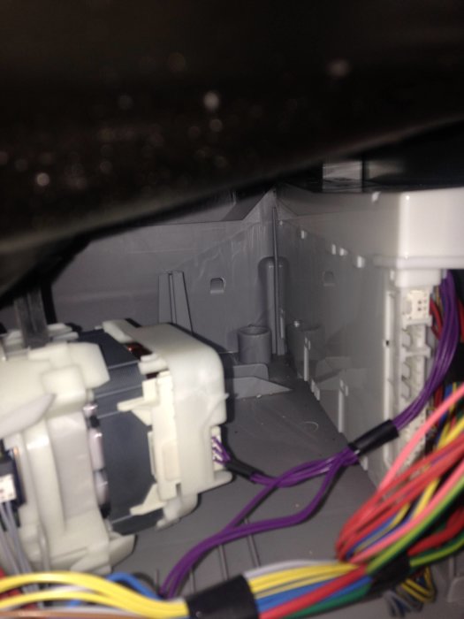 Interiör av en elektrisk apparat med kablar och komponenter, ur fokus och dåligt belyst.