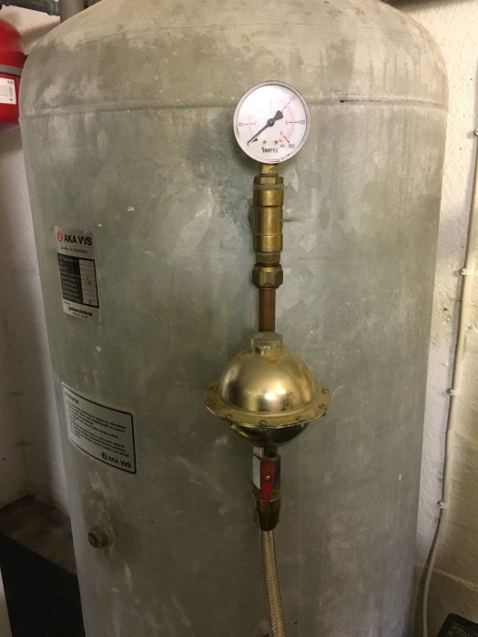 En hydrofor med mätare och kopplingar i källaren, som en del av ett VVS-system.