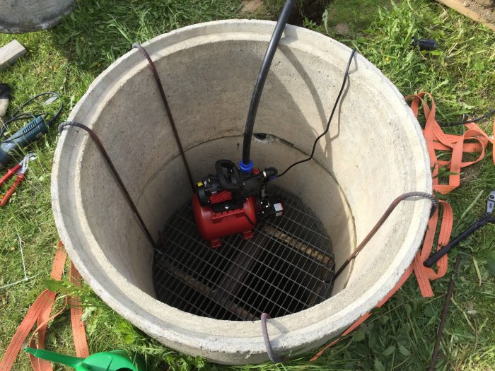Pumpautomat installerad i en gammal grävd brunn för trädgårdsbevattning.