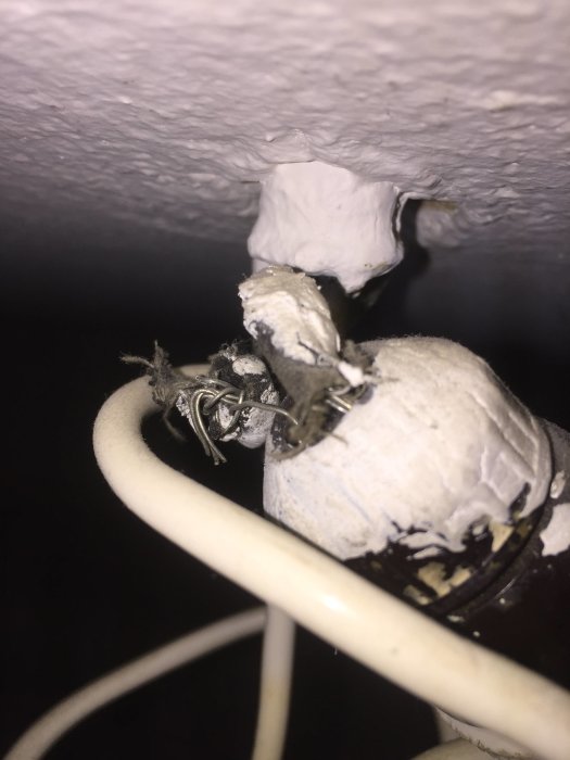 Eluttag med utstickande kablar och tejp vid renovering.