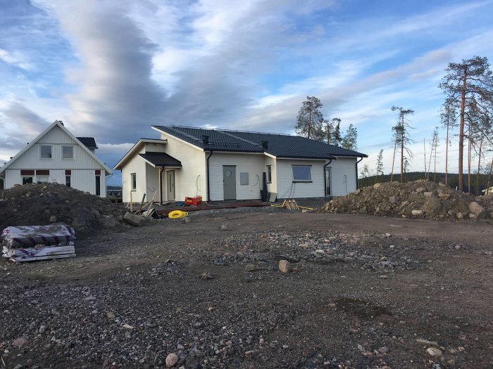 Hus under konstruktion med dubbla rör utstickande från väggen för elinstallation.